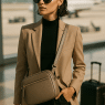 Fashion-savvy woman at airport with stylish best crossbody bag for travel ready for adventure