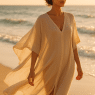 Fashionable woman wearing the best cover ups for beach on a sunlit shore at golden hour