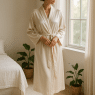 woman wearing best robes for women standing by sunlit window in cozy elegant room